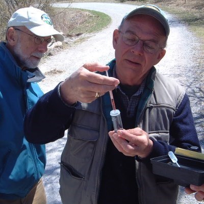 Two older gentleman looking at a water speciman