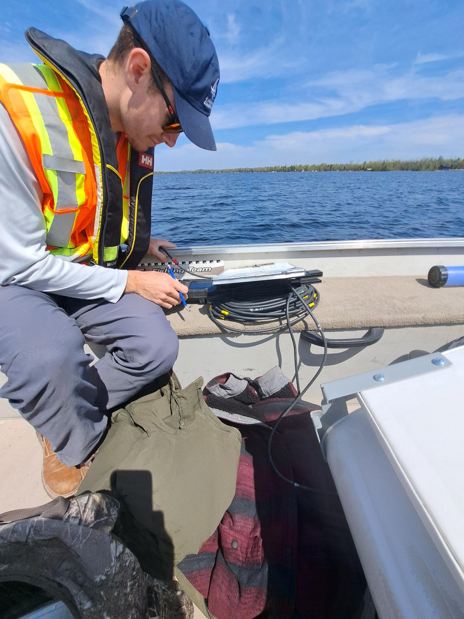 Watershed Resources Technician, Nathan Rajevski recording lake data as part of the Lake Health Monitoring program.